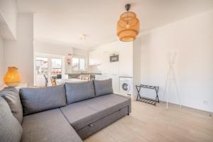 a living room with a couch and a kitchen at GuestReady - Sunny Retreat in Costa da Caparica in Costa da Caparica