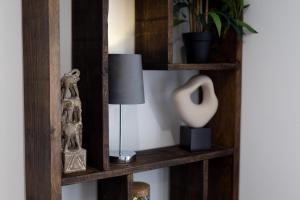 a wooden shelf with a lamp and a plant at Victoria Apartments in Skegness