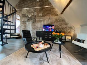 een woonkamer met een tafel en stoelen en een bakstenen muur bij Luxe en ruim appartement in Rijksmonument in Vianen