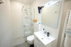a bathroom with a toilet and a sink and a shower at Appartement L'or 2 pièces de 44 m2 in Noisy-le-Sec +27 photos