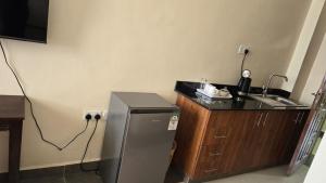 a small kitchen with a sink and a refrigerator at RCMRD EXECUTIVE SUITEs in Nairobi
