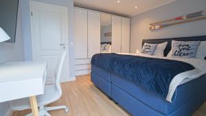a bedroom with a blue bed and a desk at Appartement Friesenloft in Tinnum
