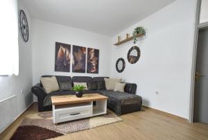 a living room with a black couch and a table at Stan Stari Grad Budva in Budva