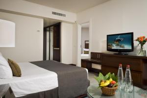a hotel room with a bed and a flat screen tv at King Solomon by Isrotel Collection in Eilat