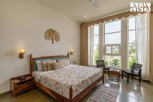 a bedroom with a bed and a large window at The Pastel Courtyard with Pvt Pool & Garden at Jaipur by StayVista in Jaipur