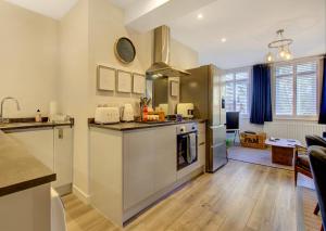 a kitchen with a sink and a stove at Stylish, business traveller friendly apartment, with free parking and Netflix in Farnborough