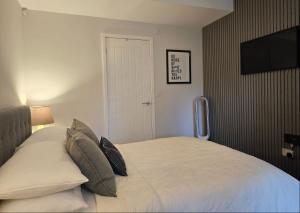a bedroom with a bed with a television on the wall at Stylish, business traveller friendly apartment, with free parking and Netflix in Farnborough +9 photos