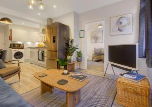 uma sala de estar com um sofá e uma mesa em Stylish, business traveller friendly apartment, with free parking and Netflix em Farnborough