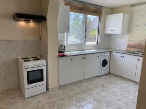 Una cocina con gabinetes blancos y un horno de estufa. en villa 58 coral bay seafront, en Peyia