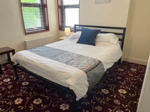 una camera da letto con un grande letto con un cuscino blu di Amazing Entire Home in Wolverhampton a Wolverhampton