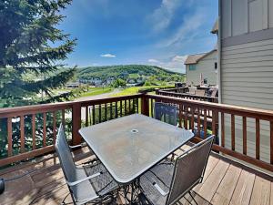 a table and chairs on a deck with a view at Its 5 OClock Somewhere in McHenry