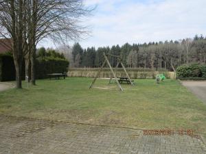 a park with a swing set in the grass at Waldwiese RE15 in Sögel