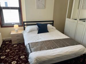 a bedroom with a bed with a blue pillow on it at Amazing Entire Home in WOLVERHAMPTON in Wolverhampton