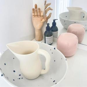 a table with a cup and a plate and bottles at BlackberryHouse in Ærøskøbing