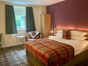 ein Hotelzimmer mit einem Bett und einem Fenster in der Unterkunft Britannia Edinburgh Hotel in Edinburgh