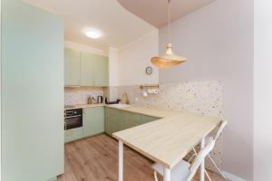 a kitchen with green cabinets and a wooden table at Apartament Gaya23 Ku Morzu in Sianozety