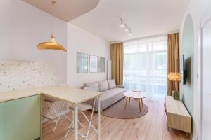 a kitchen and living room with a table and a couch at Apartament Gaya23 Ku Morzu in Sianozety