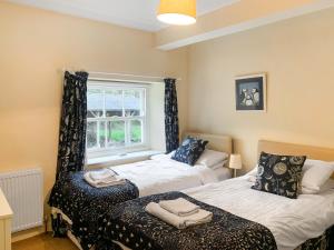 a bedroom with two beds and a window at Stable Cottage 1 in Rudston