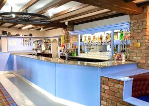 a bar with blue cabinets and a brick wall at Burrowhead Holiday Village in Isle of Whithorn