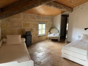 a bedroom with a bed and a chair in a room at Magnanerie en plein cœur d'un village in Collias
