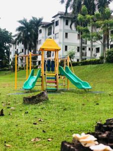um parque infantil com dois escorregas num parque em Romantic Suite by the Lake em Cyberjaya