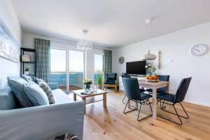 a living room with a couch and a table at Marinablick in Olpenitz +17 photos