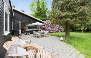 eine Terrasse mit Stühlen, Tischen und einem Baum in der Unterkunft Stunning Home In Hornbk With Kitchen in Hornbæk