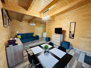 a living room with a table and a blue couch at HOME Resort RS in Moldoveneşti