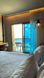 a bedroom with a bed and a view of the ocean at Suite on the beach in Haifa