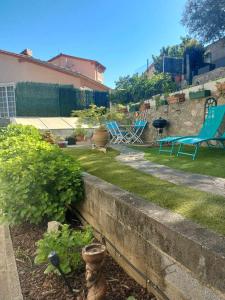 un patio con sillas azules y una pared de retención en beautiful apartment with garden, en Amélie-les-Bains-Palalda