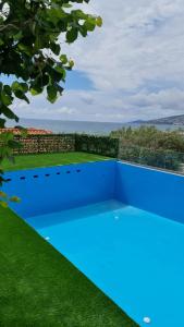 a blue swimming pool with a view of the ocean at Villa Skenderi in Sarandë