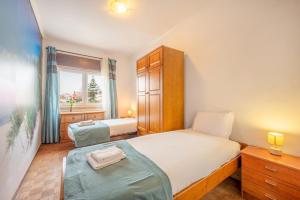 a small bedroom with two beds and a window at GuestReady - Sea Breeze in Costa da Caparica in Lisbon +21 photos
