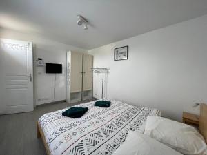 - une chambre avec un lit doté de 2 oreillers verts dans l'établissement Apt duplex spacieux 4 chambres belle terrasse aménagée près Omaha Beach et Bayeux 800 m plage et 300 m superette, à Vierville-sur-Mer