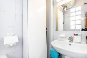 een witte badkamer met een wastafel en een spiegel bij GuestReady - Stylish Hideaway near Bercy Parc in Parijs