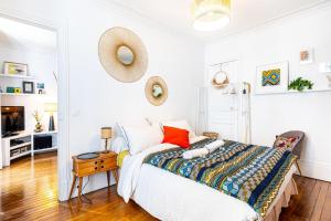 Dormitorio blanco con cama y mesa en GuestReady - Charming stay near Place de la Nation, en París