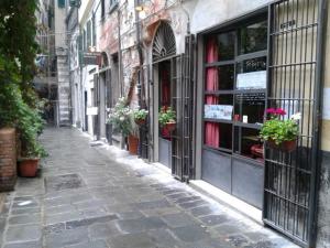 an empty street with potted plants on a building at Loft In San Lorenzo 1 & 2 in Genova