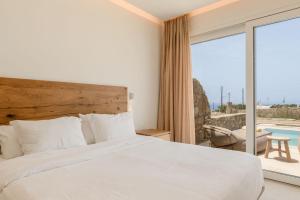 ein Schlafzimmer mit einem Bett und einem großen Fenster in der Unterkunft Aya Sofia Suites in Mykonos Stadt