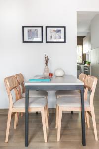 einen Esstisch mit Stühlen und einem Tisch in der Unterkunft Apartamento Coquette a 50 metros de la playa in Platja  d'Aro