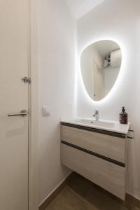 ein Bad mit einem Waschbecken und einem Spiegel in der Unterkunft Apartamento Coquette a 50 metros de la playa in Platja  d'Aro