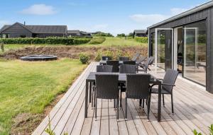 una terrazza in legno con tavolo e sedie. di Awesome Home In Haderslev With Sauna a Haderslev