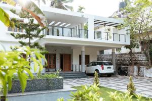 a white car parked in front of a house at Reunion Marina Villa in Udupi