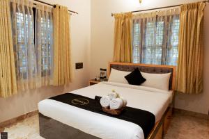 a bedroom with a bed with two towels on it at Reunion Marina Villa in Udupi