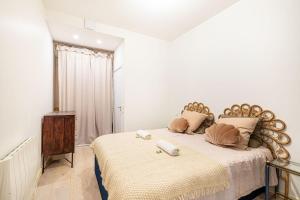 ein weißes Schlafzimmer mit einem großen Bett mit einem Kopfteil aus Holz in der Unterkunft GuestReady - Graceful stay in Parisian suburbs in Montreuil