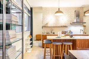 eine Küche mit einer Theke und Hockern in einem Zimmer in der Unterkunft GuestReady - Graceful stay in Parisian suburbs in Montreuil