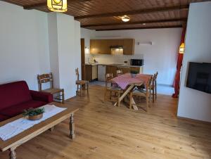 a living room and kitchen with a table and a couch at Appartementhaus Habich in Bad Kleinkirchheim