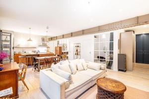 ein Wohnzimmer mit einem weißen Sofa und einem Esszimmer in der Unterkunft GuestReady - Graceful stay in Parisian suburbs in Montreuil