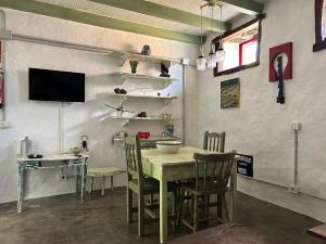 a dining room with a table and chairs and a television at Casa rural juaclo El Hierro in Taibique