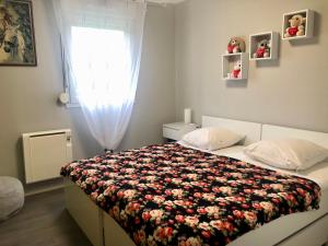 um quarto com uma cama com um cobertor floral em Appartement au calme proche centre ville em Quimper