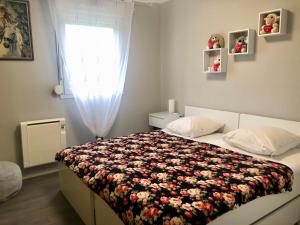 a bedroom with a bed with a floral blanket at Appartement au calme nature et centre ville in Quimper