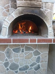 Un horno de ladrillo con fuego. en Anestis Apartments & rooms, en Palaión Tsiflíkion